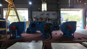 Industrial setting with large blue machines and a worker.